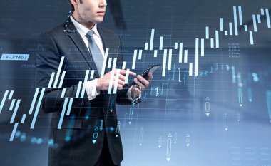 Resmi takım elbiseli hırslı iş adamı akıllı telefonu tutuyor ve ekrana dokunuyor. Borsadaki mali durumu analiz etme ve davranışlarını tahmin etme kavramı. Arkaplanda bulanık ofis