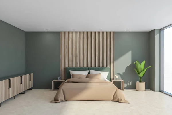 Interior with bed, sideboard, light moss green walls and headboard of the bed with beige sheets, wooden details, side tables, plant, light concrete flooring and panoramic view. 3d rendering