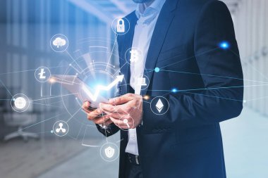 Resmi takım elbiseli bir iş adamı tablet taşıyor. Kripto para biriminin finansal piyasadaki değerini analiz etme kavramı. Şifreleme para birimi simgeleriyle dijital arayüzün hologramı