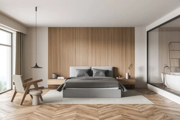 Bedroom interior with grey bed, wall panelling, armchair with coffee table, rug, accent pendant lamp, parquet and big glass enclosure in the wall. A concept of modern house design. 3d rendering