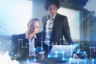 İş kadını akıllı telefon kullanır ve kameraya bakar. Resmi takım elbiseli iş adamı dizüstü bilgisayara bakar. Ofis geçmişi. dijital forex finansal grafiklerinin örtüşmesi