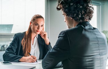İş adamı ve iş kadını resmi takım elbiseli iş görüşmesindeler. Şirket için yeni yetenekli adaylar arıyorum. İşe alım departmanı. Hanımefendi not alıyor.
