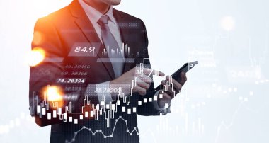Resmi takım elbiseli bir iş adamı akıllı telefonuyla internette geziniyor. Eski şamdanlar, bar diyagramı ve ön planda grafik. Web 'de işbirliği ve ağ kavramı