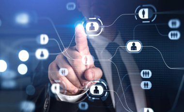 Resmi kıyafet giyen işadamı parmağıyla insanların ikonlarıyla dijital arayüze dokunuyor. Arka planda bulanık bir ofis. İş hayatında iletişim ve işbirliği kavramı