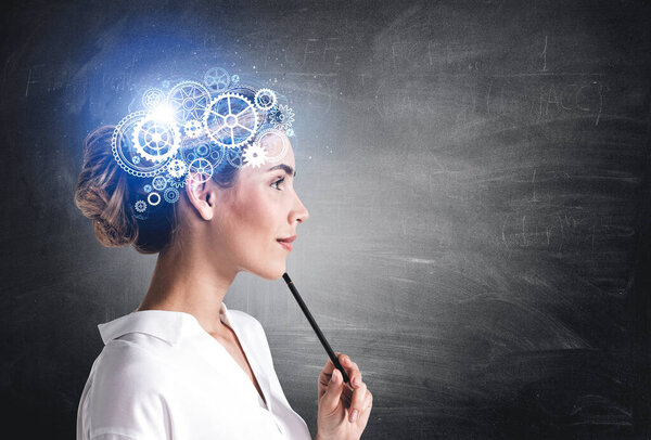 Thoughtful teacher wearing white shirt is thinking and pondering about new creative ideas for a lesson. Chalkboard in the background. Concept of modern technology and inspiration for studying