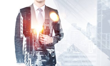 Resmi takım elbiseli genç işadamı ayakta duruyor. New York 'un şehir merkezindeki gökdelende arabalar ve trafik var. Başarılı işveren kavramı