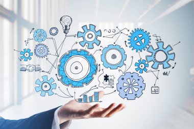 Resmi takım elbiseli bir iş adamı elinde çark, ampul, bulmaca, bar ve pasta diyagramları ve tokalaşma ikonlarıyla renkli bir çizim tutuyor. Yaratıcı iş fikri için düşünme kavramı