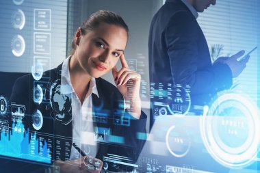 Resmi takım elbise giyen gülümseyen iş kadını ve işadamı dizüstü bilgisayar ve akıllı telefonda birlikte çalışıyorlar. Ofis arka planda. Dünya, çubuk ve turta diyagramlarının hologramıyla dijital arayüz