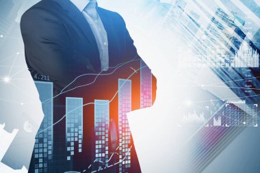 Resmi takım elbiseli bir iş adamı çapraz kol pozisyonunda duruyor. Arka planda şehir gökdelenleri var. Ön planda mali açıdan yükselen grafikler ve bar diyagramı var. Başarılı ticaret kavramı