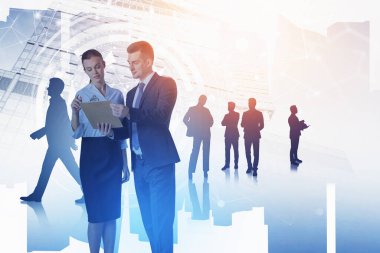 Bir grup iş adamı, şirketleri için yeni çalışma stratejilerini tartışıyor. Arka planda gökdelen var. Takım çalışması, iletişim ve işbirliği kavramı