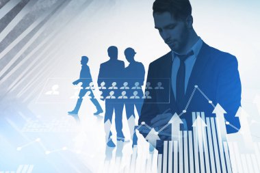 Bir grup iş adamı birlikte çalışıp not tutuyorlar. Önplanda bar diyagramı, grafik ve insan kaynakları ile dijital arayüz. Takım çalışması, işbirliği ve iletişim kavramı