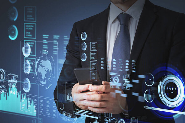 Бизнесмен в формальном костюме печатает на смартфоне голограмму цифрового интерфейса с глобусами, барами и диаграммами пирогов. Концепция облачного хранения данных и информационной безопасности и связи