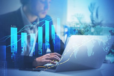 Resmi takım elbiseli bir iş adamı dizüstü bilgisayarda mesaj yazıyor. Arka planda masa olan ofis işyeri. Finansal grafik ve bar diyagramı, ön planda dijital harita. Ticaret kavramı