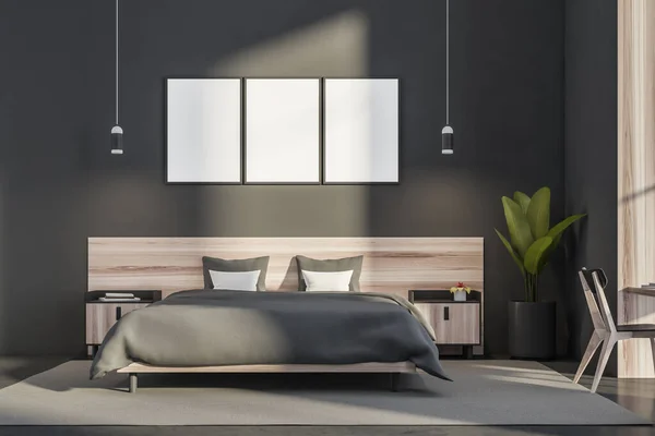 Bedroom interior with three empty canvas, two pendant lights, a chair, a rug, a wooden bed with bedside tables, a grey wall and a concrete floor. A concept of modern hotel design. 3d rendering