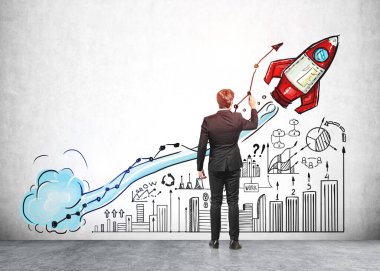 Resmi takım elbiseli iş adamı, beton duvardaki büyük roket fırlatma, iş, plan, takım çalışması, bar ve pasta diyagramı ile renkli çizimlere dokunuyor. Yaratıcı fikirler için hayal gücü kavramı