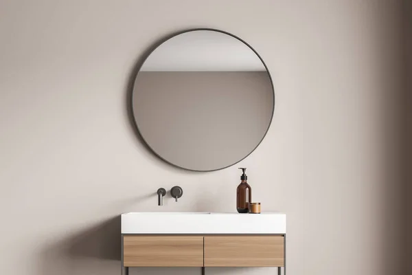Μπεζ Τοίχο Μπάνιου Ένα Κομψό Στρογγυλό Καθρέφτη Πάνω Από Ματαιοδοξία — Φωτογραφία Αρχείου