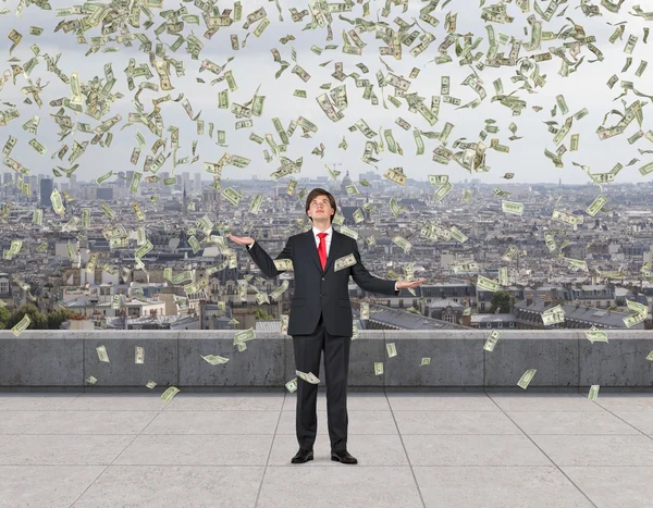 Businessman catching flying money — Stock Photo, Image