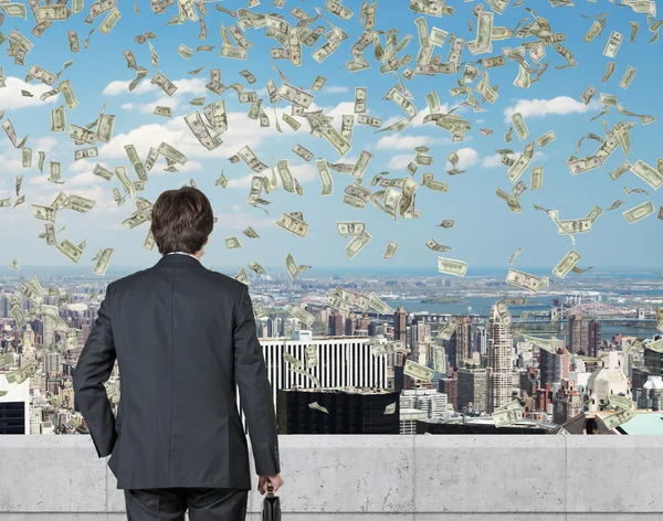 Businessmanlooking to flying money — Stock Photo, Image