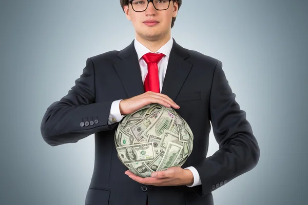 Hombre de negocios sosteniendo bola dólar — Foto de Stock