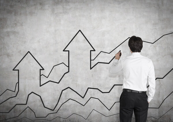 бизнесмен рисует график и стрелку
