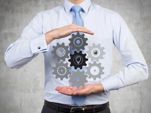 Man holding cogs and gears — Stock Photo, Image