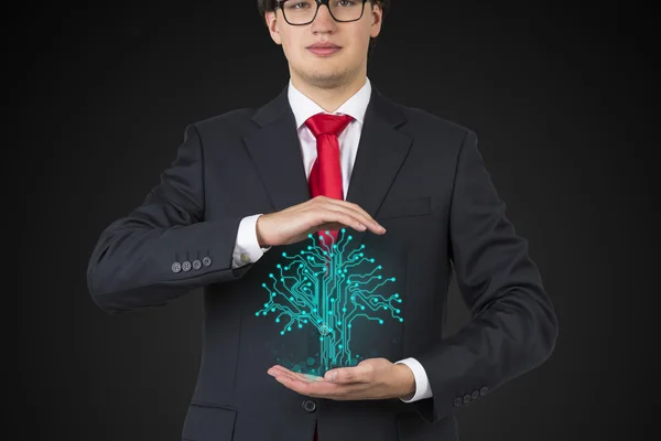 Businessman holding electronics tree — Stock Photo, Image