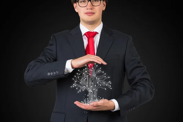 Affärsman holding elektronik träd — Stockfoto