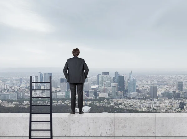 Homme d'affaires en costume debout sur le mur — Photo