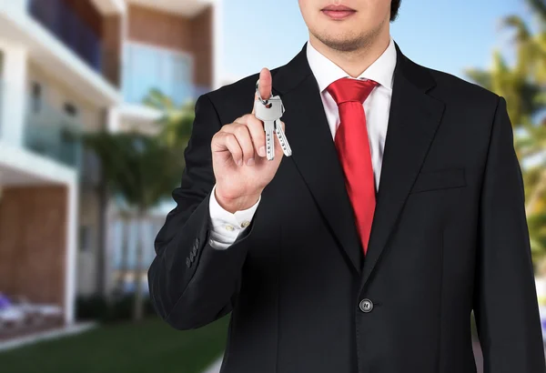 Empresário está segurando uma chave — Fotografia de Stock