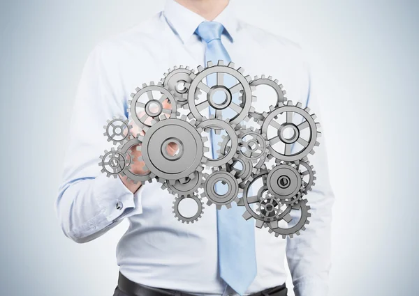 Businessman holding gold gears — Stock Photo, Image