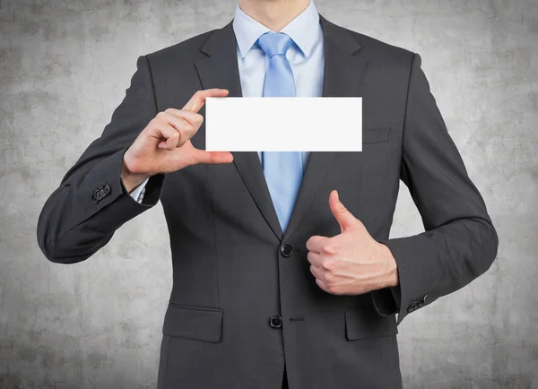 Empresario sosteniendo cartel en blanco — Foto de Stock