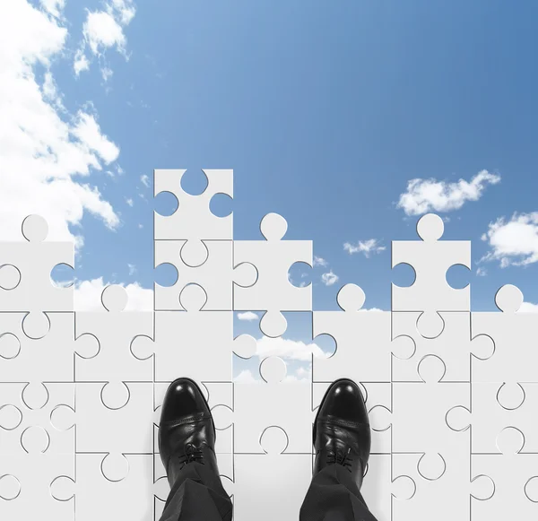 Uomo d'affari in piedi sul puzzle — Foto Stock