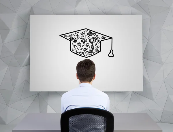 Businessman  looking on bachelor cap — Stock Photo, Image