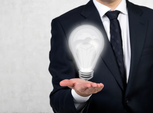 Businessman holding lamp — Stock Photo, Image