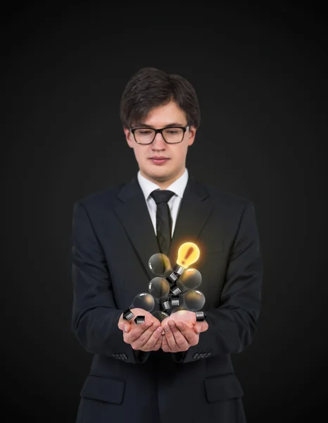 Businessman holding bulbs — Stock Photo, Image