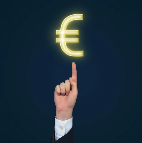 Hand pointing to gold euro — Stock Photo, Image