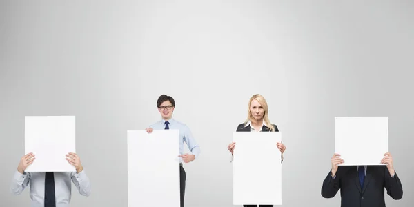 Empresários segurando cartaz em branco — Fotografia de Stock