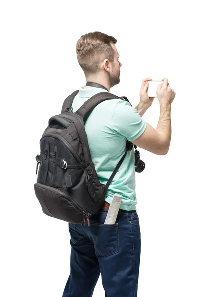 Молодой человек с рюкзаком делает фото на белом фоне — стоковое фото