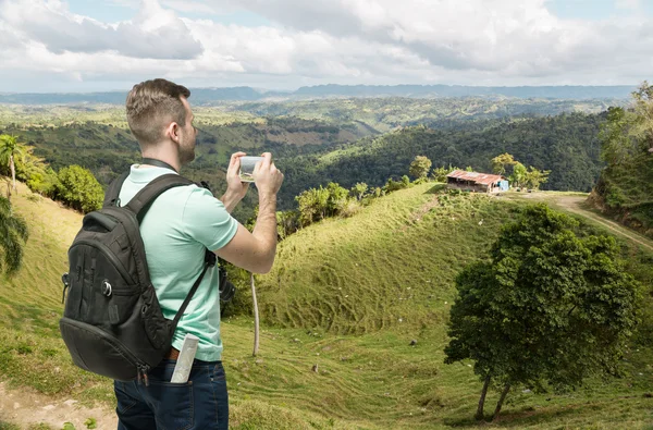 Hombre de turismo tomando fotos de colinas en Dominicana — Foto de Stock