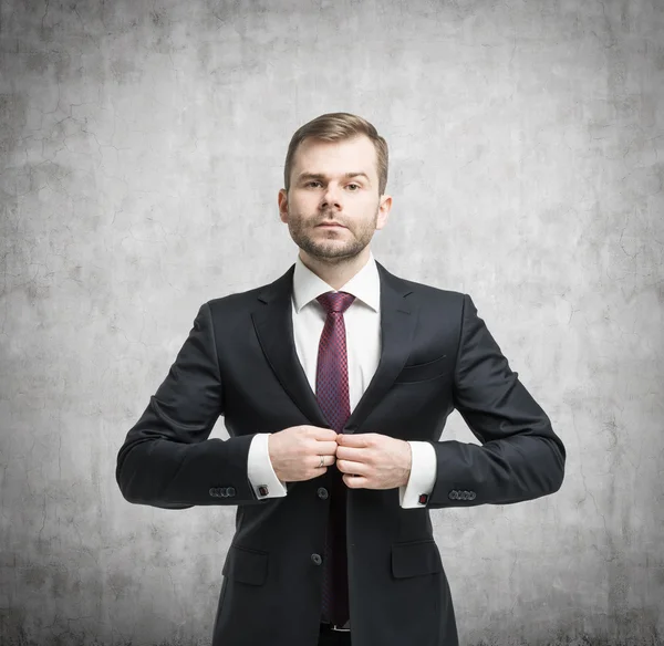 Businessman standing in front of the concrete wall — Stock Photo, Image