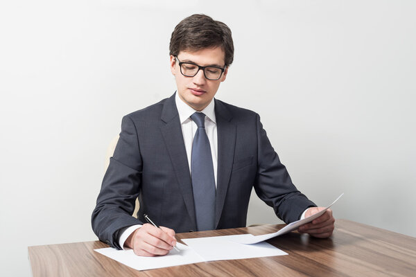 Молодой бизнесмен проверяет контракты

