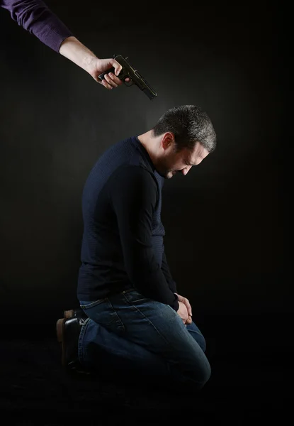 A man on the knees under the gun — Stock Photo, Image