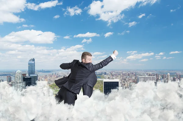 Businessman is flying over the central park in New York through the cloud — Stock Photo, Image