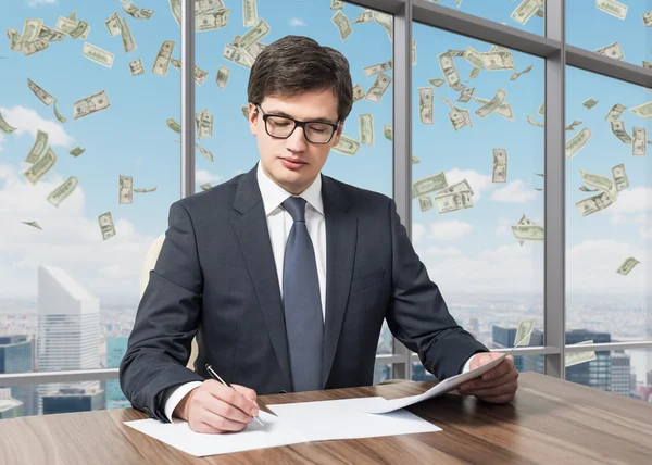 Handsome legal consultant is dealing with due diligence process in a modern skyscraper office with a panoramic New York view. Money are falling down from the sky. — Stock Photo, Image