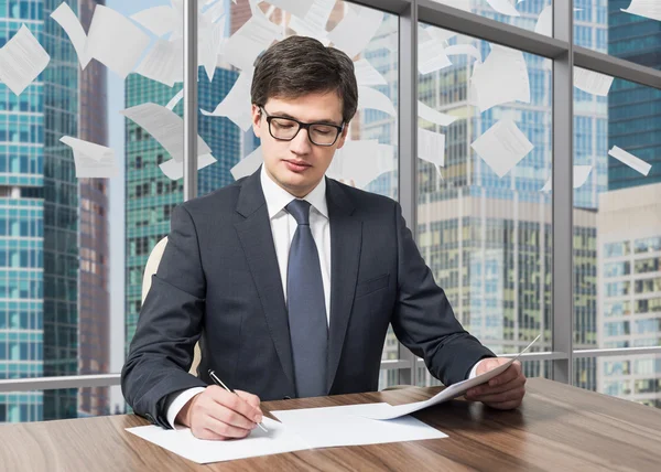 Un beau consultant juridique s'occupe du processus de diligence raisonnable dans un bureau moderne de gratte-ciel avec une vue panoramique sur la ville de Moscou. Des pages de contrat tombent du ciel . — Photo