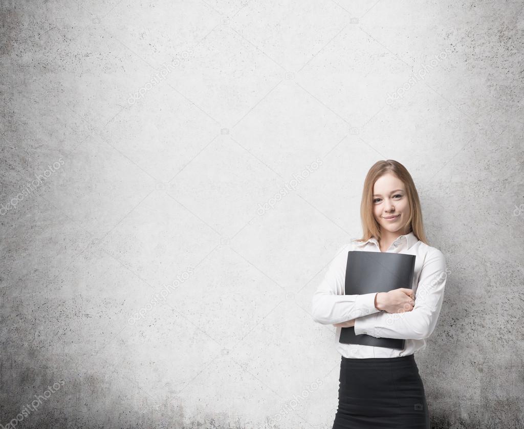 Young beautiful business lady is holding a black document case. A concept of legal services. Concrete background.