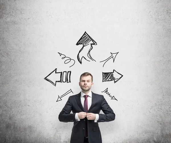 Businessman is standing surrounded by arrows in different direction. A concept of decision making process. — Stock Photo, Image