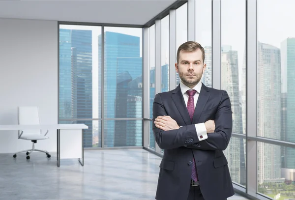 Young professional is standing in a contemporary glass office in New York. — Stock Photo, Image