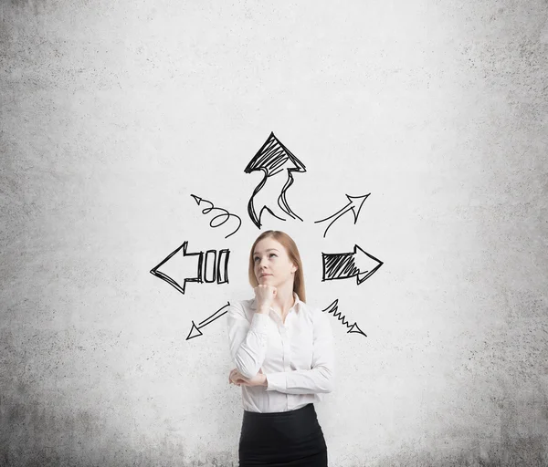 Business woman is standing surrounded by arrows — Stock Photo, Image