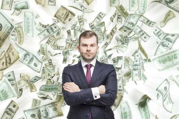 Fiatal, jóképű üzletember áll jegyzeteket dollár zuhan. A koncepció a karrier siker. — Stock Fotó